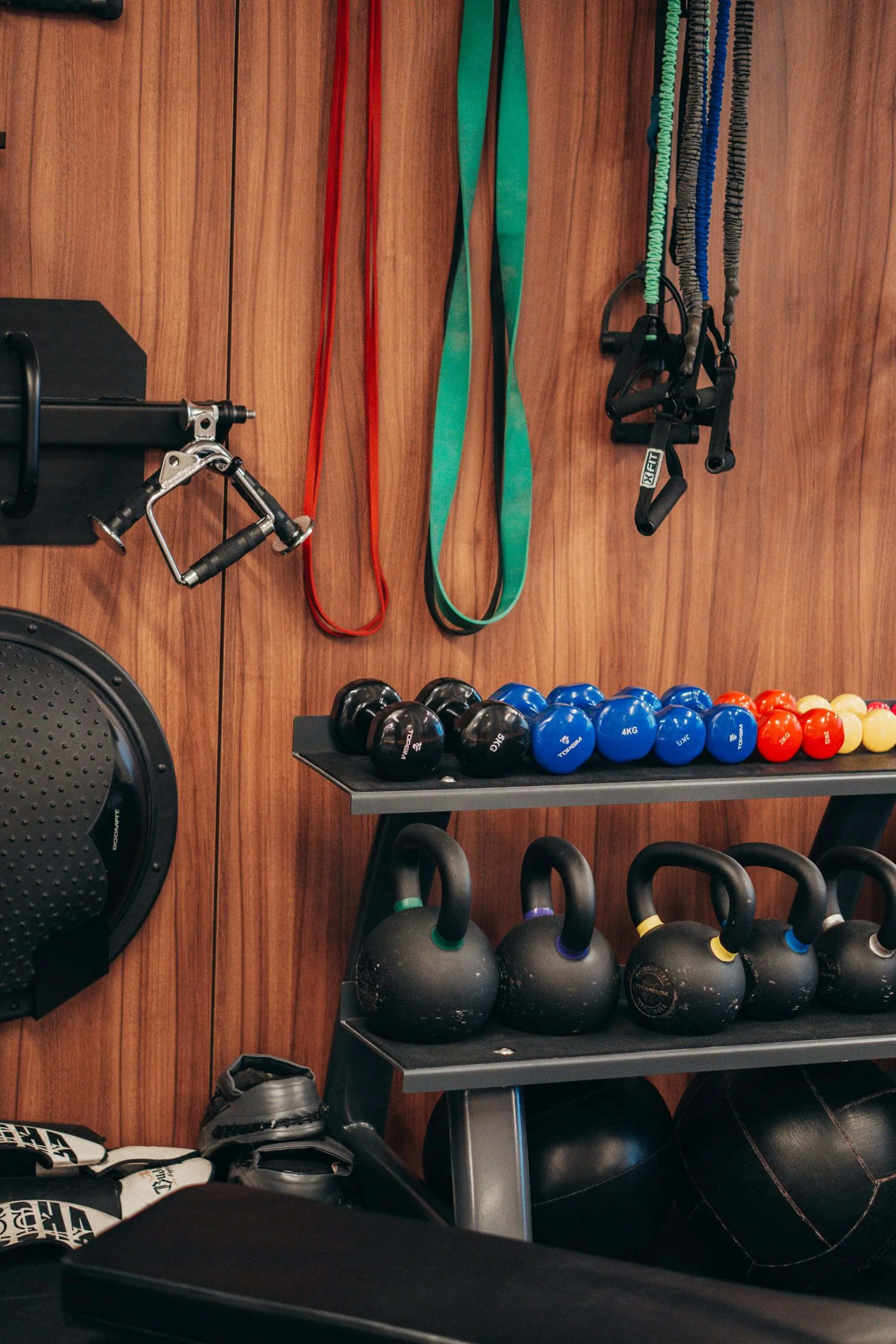 Detalhe de equipamentos de treino, kettlebells e acessórios no estúdio PT do Bairro