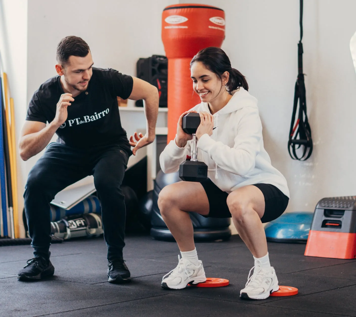 Aluna a realizar agachamento em treino funcional focado na postura