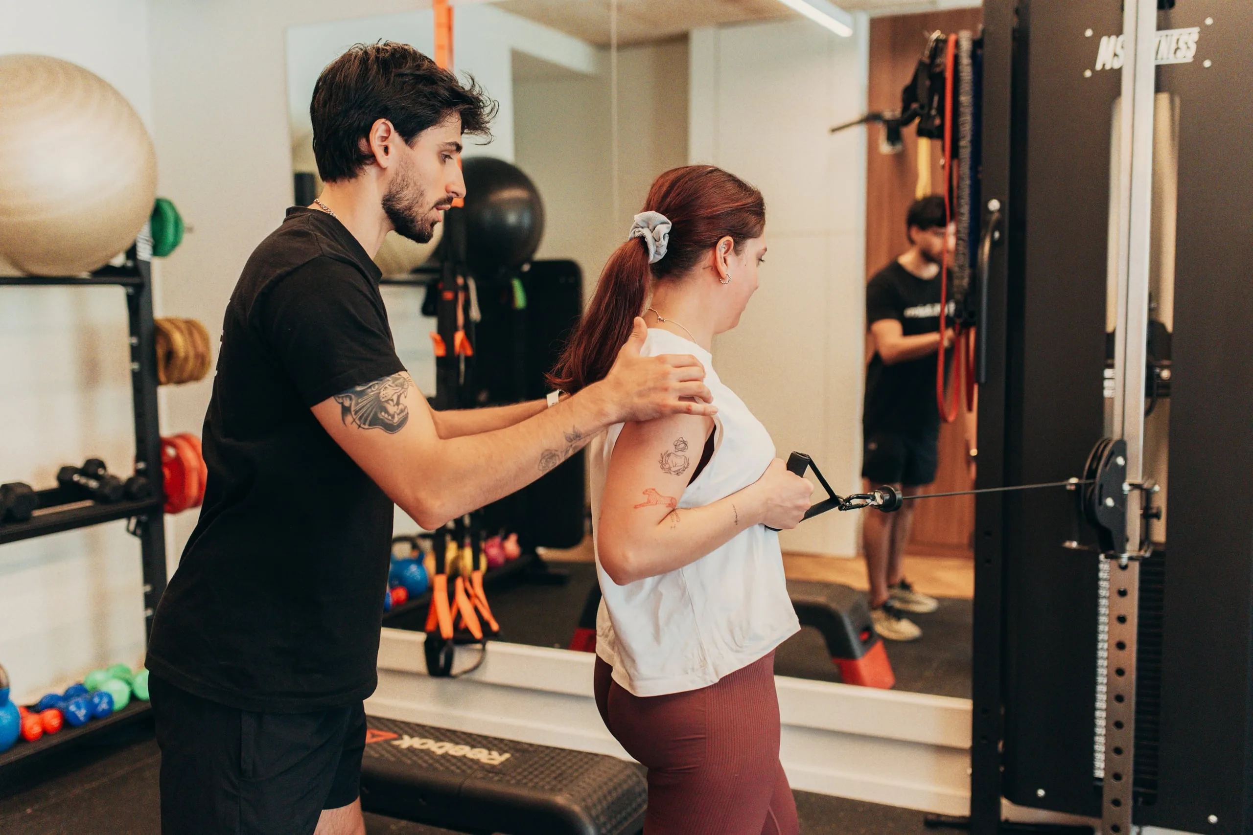 Personal Trainer a orientar exercício de correção no estúdio PT do Bairro Telheiras
