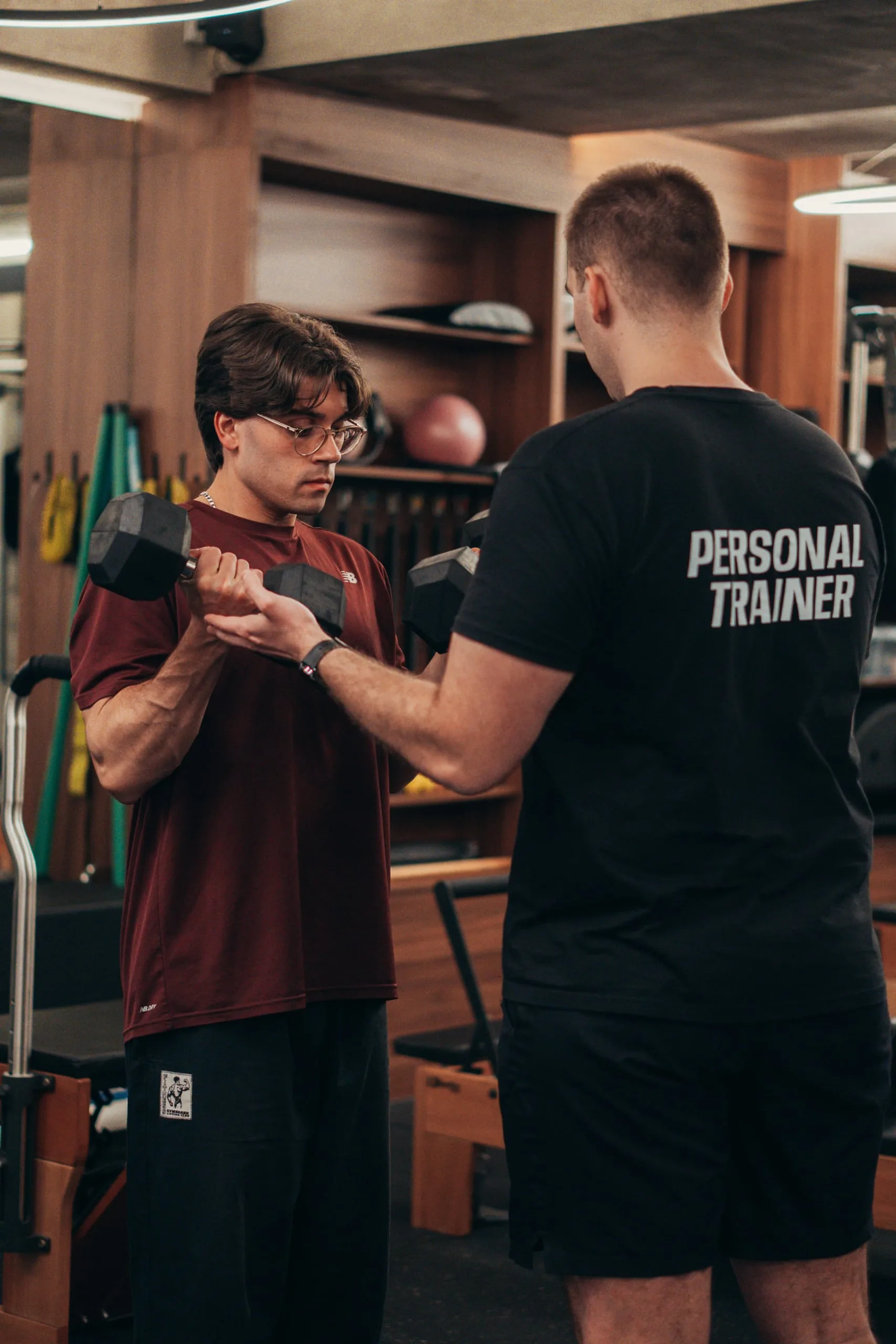 Personal Trainer a ensinar técnica de levantamento de peso em treino individual