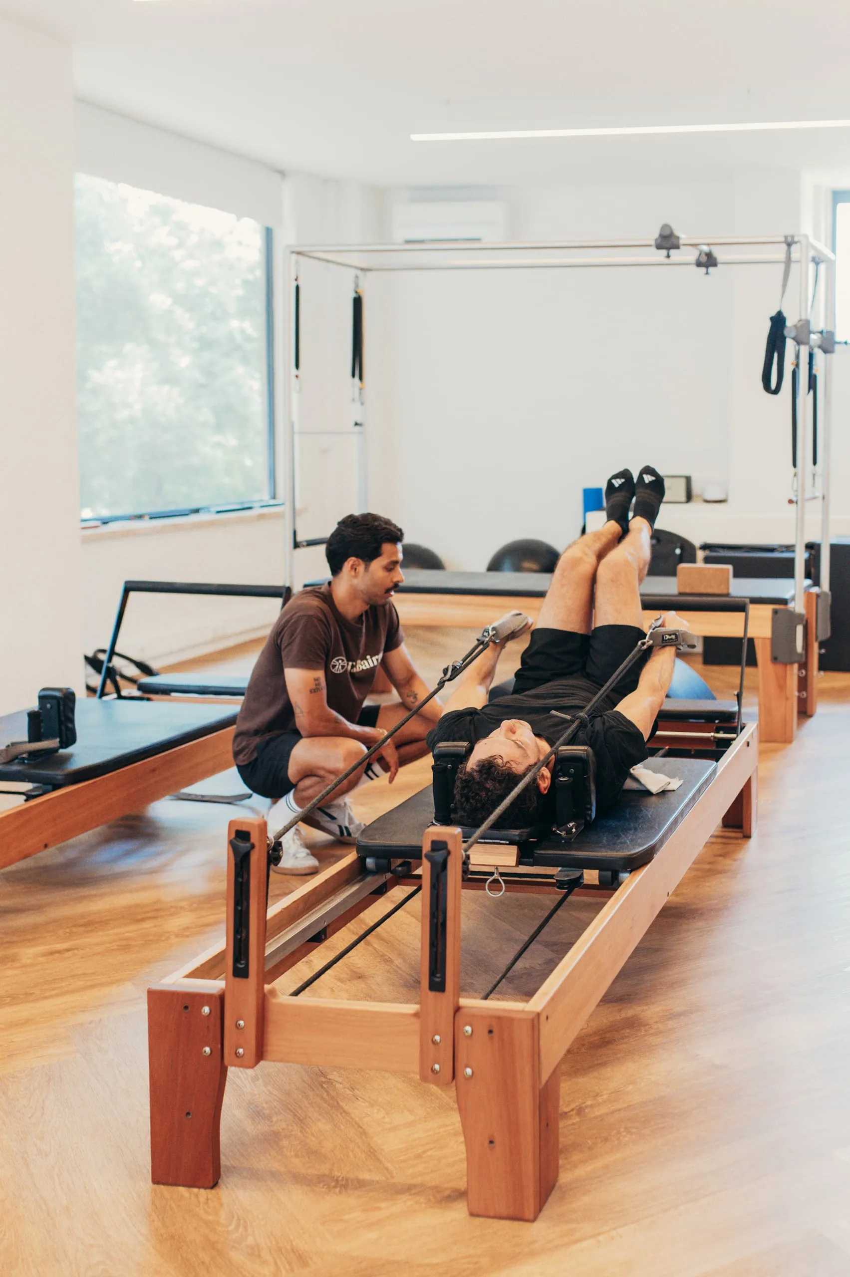 Treino de Pilates com grandes equipamentos orientado por Personal Trainer