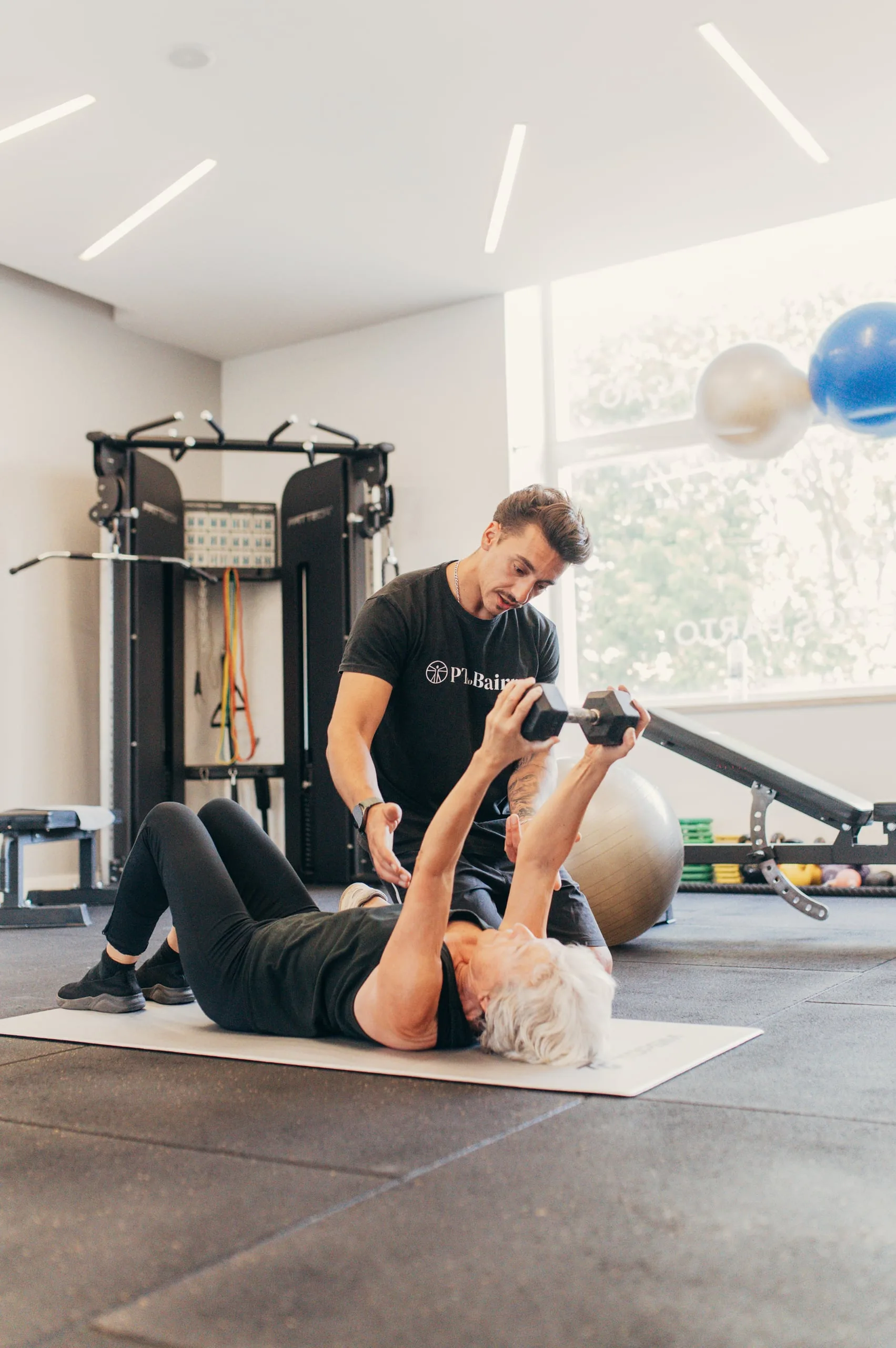 Personal Trainer a orientar exercícios de reabilitação física deitado
